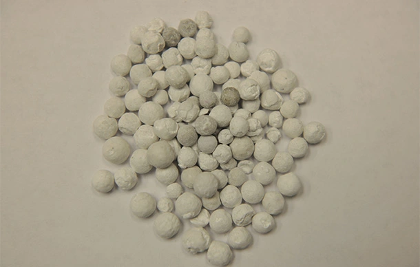Pile of rounded catalyst spheres on a table.